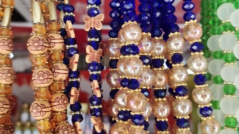 Multicolored plastic cheap necklaces hanging at the tourist market. Stock Footage 217757819