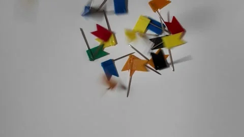 Multicolored plastic flag push pins fall on random locations Scattered on a.. Stock Footage 328136621