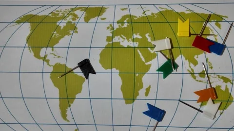 Multicolored plastic flag push pins fall on random marking locations on gre.. Video stock 328136624