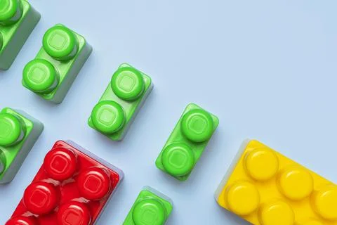 Multicolored plastic kids constructor on blue background. Flat lay top view Stock Photos