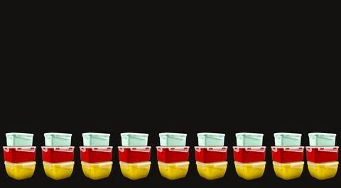 Multicolored plastic lunch boxes on a black background from both sides Stock Photos