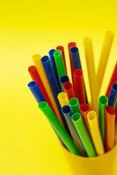 Multicolored Plastic Straws in a Yellow Container for Party Decor Stock-Fotos