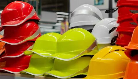 Multicolored plastic worker hardhats store. Stock Photos