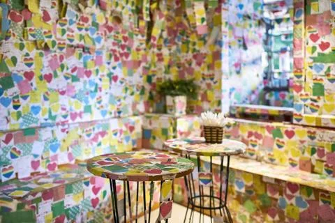 Multicolored postcards pasted on interior of unusual cafe Stock-Fotos