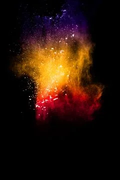 Multicolored powder explosion on black background. Stock Photos