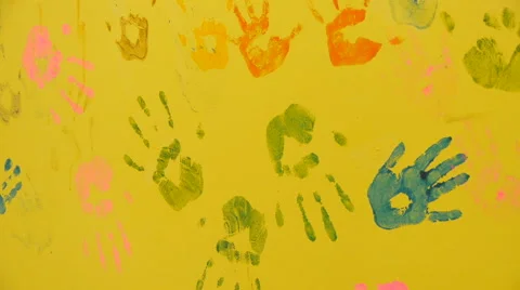 Multicolored prints of hands on the yellow wall, close-up Stock Footage