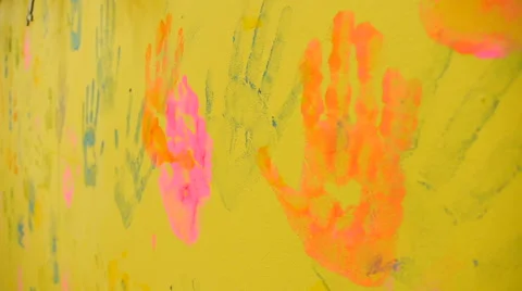 Multicolored prints of hands on the yellow wall, close-up Stock Footage