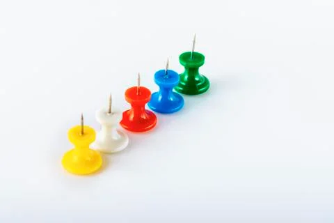 Multicolored push pins on white background. Close-up. Stock Photos