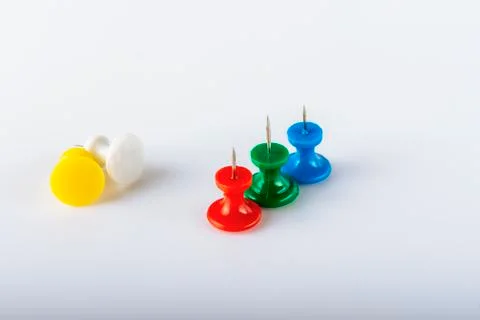 Multicolored push pins on white background. Close-up. Stock Photos