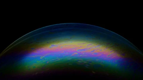 Multicolored rainbow iris of soap bubble. Fantastic colorful planet on black Stock Footage 125620017