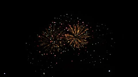 Multicolored red lilac and green bright sparks of fireworks on the black sk.. 库存影片 307439893