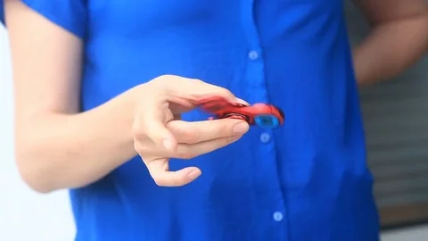 Multicolored, red-yellow-blue hand spinner, or fidgeting spinner, rotating on Stock Footage 76868657