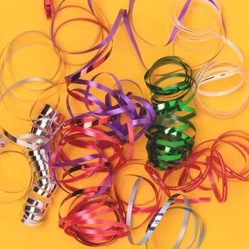 Multicolored ribbons on a yellow background. Stock Photos