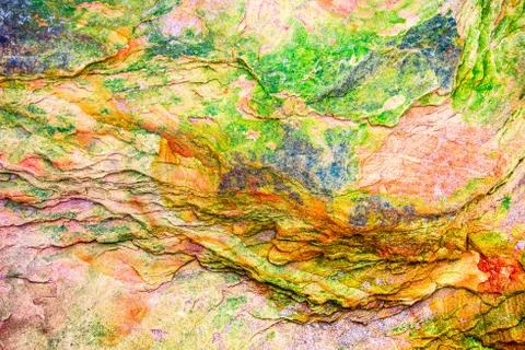 Multicolored rock wall from bottom sediments red orange dark rays crack smoot Stock Photos
