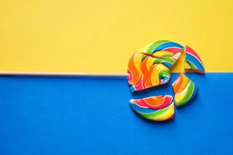 A multicolored round lollipop is split into pieces. Photo in two colors: blue Stock Photos