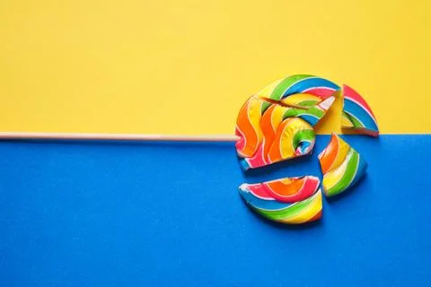 A multicolored round lollipop is split into pieces. Photo in two colors: blue Foto stock