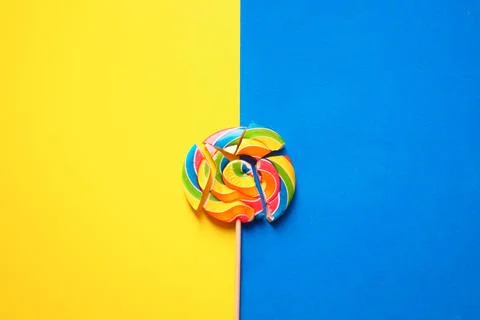 A multicolored round lollipop is split into pieces. Photo in two colors: blue Stock Photos