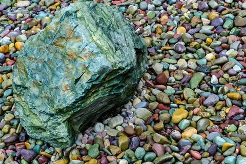 Multicolored rounded stones in the interior of a flowerbed near a recreatio.. Stock-Fotos