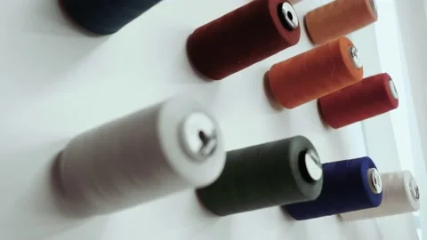 Multicolored sewing spools of thread hang on the wall in neat rows. Stock Footage 134156470