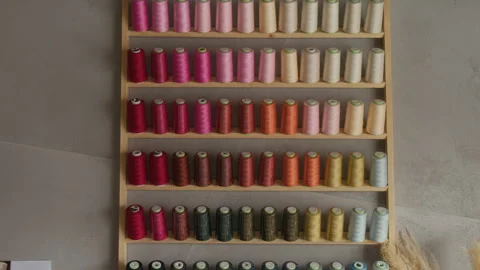 Multicolored Sewing Thread on Bobbins on Wall in Dressmaking Workshop Stock Footage 315773867