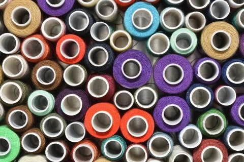 Multicolored sewing thread in spools top view Stock Photos