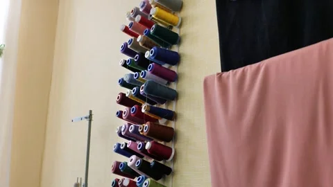 Multicolored sewing threads hang on the wall in the studio.Cotton thread spools Stock Footage 299832769