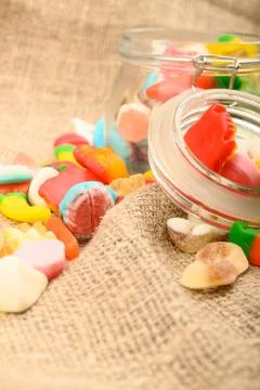 Multicolored shaped marmalade on a background of rough homespun fabric close- Stock Photos