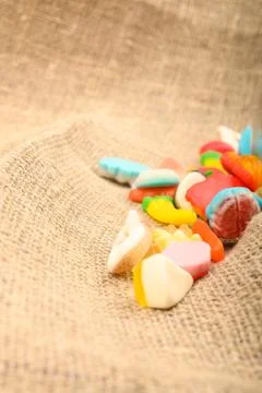 Multicolored shaped marmalade on a background of rough homespun fabric close- Stock Photos