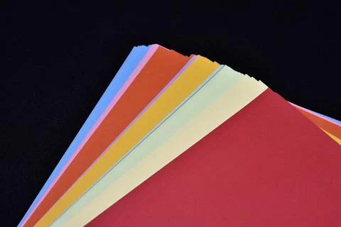 Multicolored sheets of paper on a black background. Colored office paper. A.. Foto stock