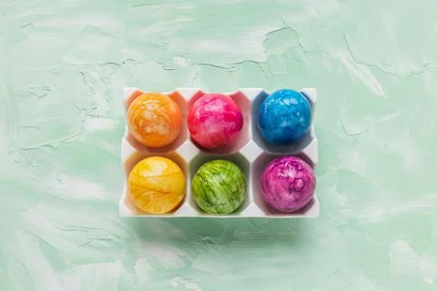Multicolored six Easter eggs in porcelain storage organizer box on green Stock Photos