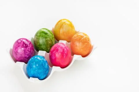 Multicolored six Easter eggs in porcelain organizer box on white background Stock Photos