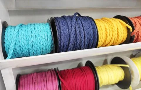 Multicolored spools of thread arranged in a composition on a store shelf Foto stock