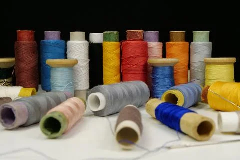 Multicolored spools thread. Spools of multi-colored threads lies on white table Photos