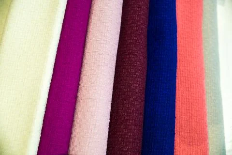 A multicolored stack of fabrics - the fabrics lie on top of each other Stock Photos