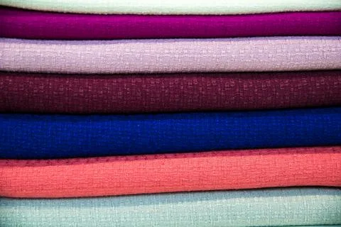 A multicolored stack of fabrics - the fabrics lie on top of each other Stock Photos