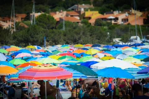 Multicolored sun umbrella on the beach during holidays Stock Photos