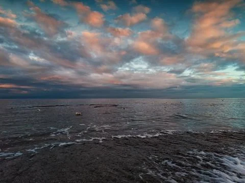 Multicolored sunset on the sea, clouds, shore Stock Photos