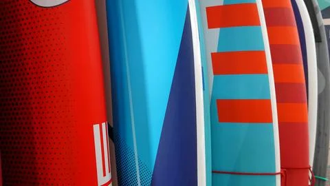 Multicolored surf boards different sizes and colors surfing boards on stand Stock Photos