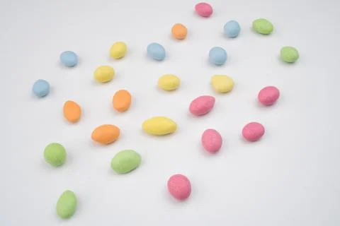 Multicolored sweets scattered on the white table Stock Photos