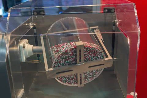 Multicolored tablets are mixed in a drum. Industry Stock Photos