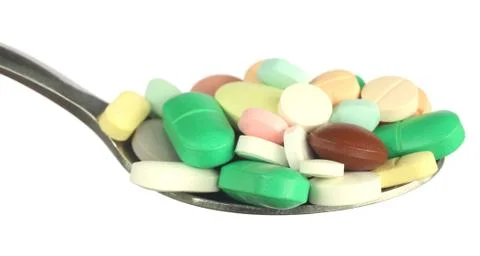 Multicolored tablets on a spoon Stock Photos
