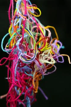 Multicolored tangled threads for needlework on black background Stock Photos