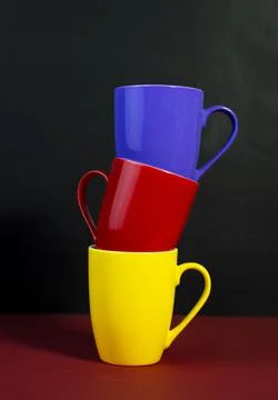 Multicolored Tea Cups Arranged Creatively on Red and Black Background Stock-Fotos