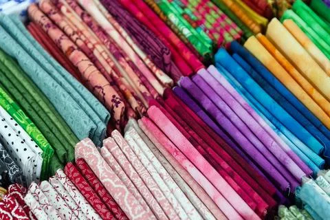 Multicolored textiles on the counter of the store Stock Photos