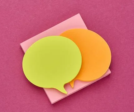 Multicolored thought cloud-shaped sticky notes on a square block of paper w.. Stock Photos