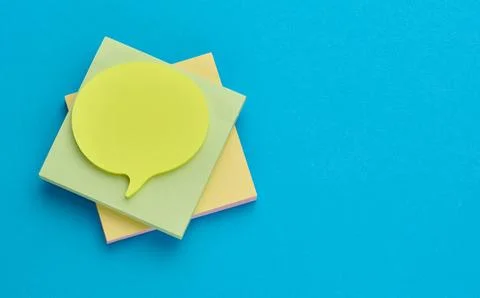 Multicolored thought cloud-shaped sticky notes on a square block of paper w.. Stock Photos