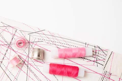 Multicolored thread coils on white background. Sewing supplies, thimble, pattern Foto stock