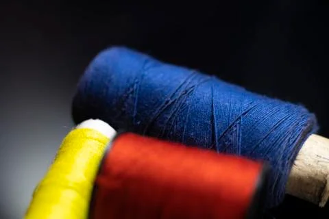 Multicolored thread reels on a black background macro photo. Stock Photos