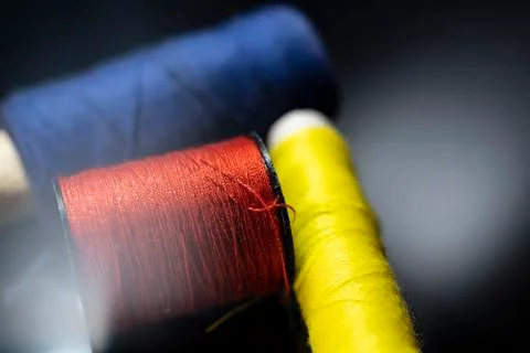 Multicolored thread reels on a black background macro photo. Stock Photos