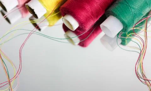 Multicolored threads in the coils reflected on the surface of the mirror flat Stock Photos